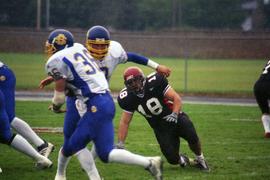 Football player Charlie Cosgrove (#18) goes for the tackle, St. Cloud State University