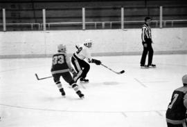 St. Cloud State hockey player Bob Motzko passes the puck during a men's hockey game against St. Scholastica