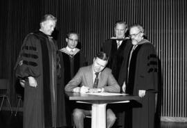 President Charles Graham signs the Phi Kappa Phi charter with H. Beresford Menagh, Thomas Park, John Erickson, and David Sorenson look on, St. Cloud State University