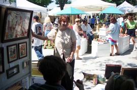 A woman examines a painting, Lemonade Concert and Art Fair, St. Cloud State University