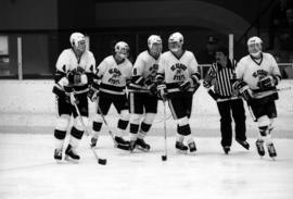 Hockey players skate together during a game break against the University of Wisconsin-Eau Claire