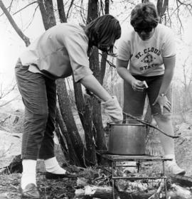 Students cook food on a campfire, St. Cloud State University