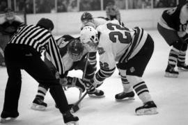 Hockey player Herm Finnegan and a University of Alaska-Anchorage player face off during a hockey game