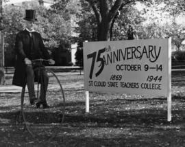 Herbert Clugston rides a bike to celebrate the school's 75th anniversary, St. Cloud State University