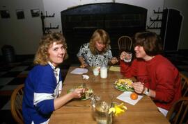 Three women sit togther, Alnwick Castle dining hall, St. Cloud State University