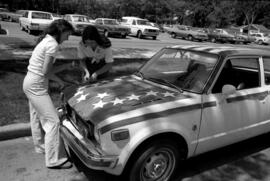 Two women decorate a car in honor of the bicentennial, St. Cloud State University