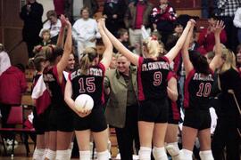 Volleyball team celebrates with Dianne Glowatzke after a game, St. Cloud State University