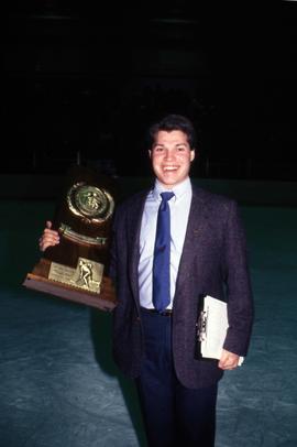 Hockey assistant coach Bill Ries with the Division III third place trophy for hockey, St. Cloud State University