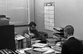 Two men confer in the Chronicle newspaper newsroom, St. Cloud State University