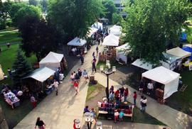 People walk on a sidewalk looking at vendors' booths, Lemonade Concert and Art Fair, St. Cloud State University