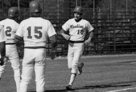 Jim Eisenreich is greeted at home plate by teammates during a St. Cloud State University baseball game against Augsburg College