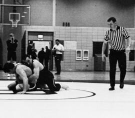 Mike Rybak wrestles another man, St. Cloud State University