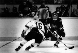 St. Cloud State hockey player Brian Cook avoids Minnesota Gopher Todd Richards at the Hall of Fame game in Eveleth, Minnesota