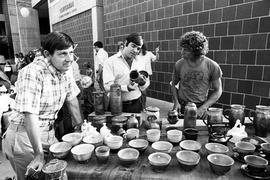 Three men examine pottery, Lemonade Concert and Art Fair, St. Cloud State University