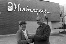 Steve Lindgren hands Rosie Moran a check in front of the Herberger department store in downtown St. Cloud, St. Cloud State University