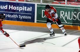 Hockey player Alison Ribar shoots a puck during a game, St. Cloud State University