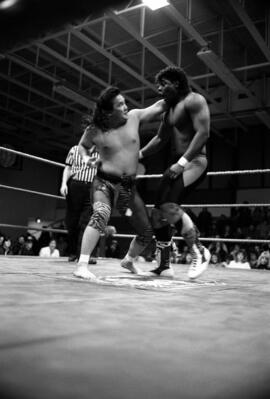 Wrestler Pat Tanaka hits Derrick Dukes during a match at the Sauk Rapids High School