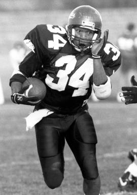 Football player Charles Dean runs with the football, St. Cloud State University