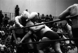 Wrestler Andre the Giant hits Ken Patera, Bobby Duncum and Bobby Heenan in the ring corner during a wrestling match, St. Cloud State University