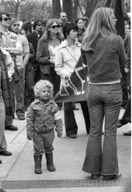 A boy stands among protestors, Day of Peace protest, St. Cloud State University