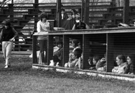 St. Cloud State University softball players gather in a dugout in a game against Winona State