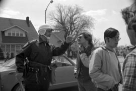 A policeman talks to a prostestor, Day of Peace protest, St. Cloud State University