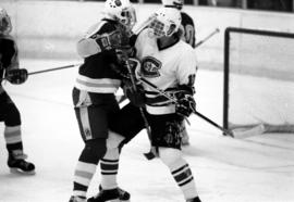 Two hockey players struggle for position in front of the net, St. Cloud State University