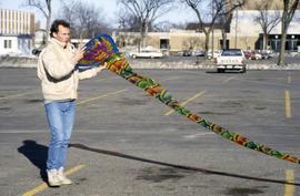 A man flies a kite in a parking lot, St. Cloud State University