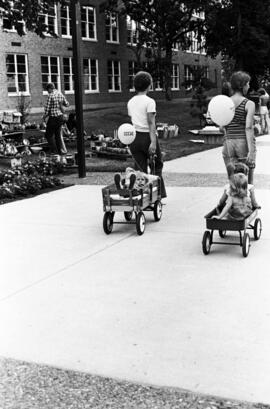Children are pulled in two wagons, Lemonade Concert and Art Fair, St. Cloud State University